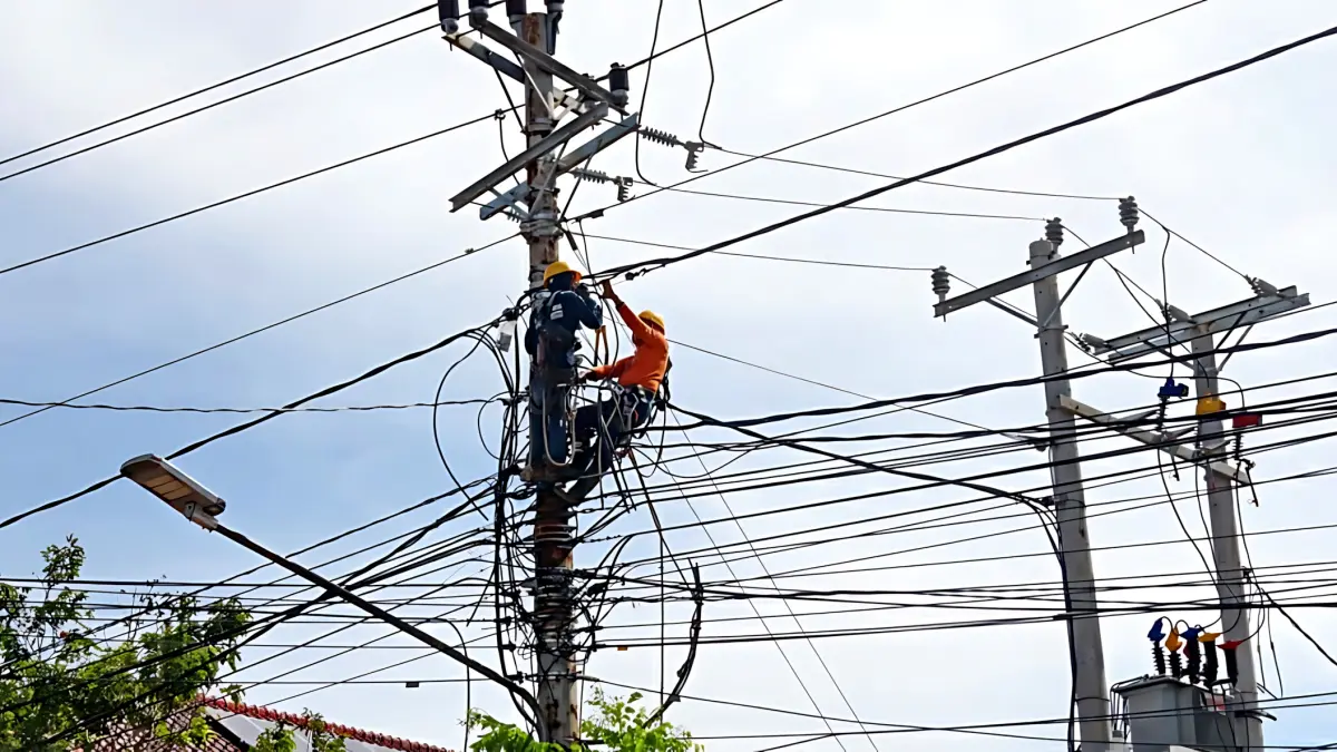PASANG KABEL : Teknisi listrik saat bergelut dengan kabel listrik dan internet di Kota Pekalongan yang cukup semrawut.(Lutfi Hanafi/Jawa Pos Metro Pekalongan)