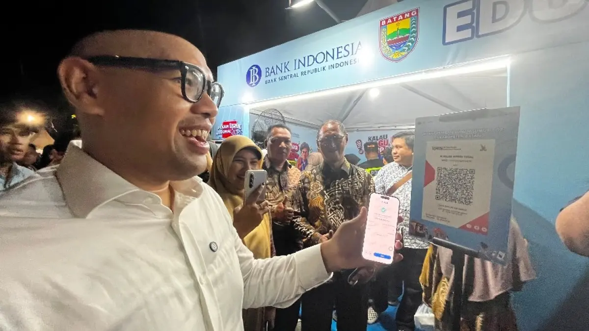KEMERDEKAAN: Bupati Batang M Faiz Kurniawan saat mencoba menscan QRIS di acara makan gratis di Jalan Veteran.