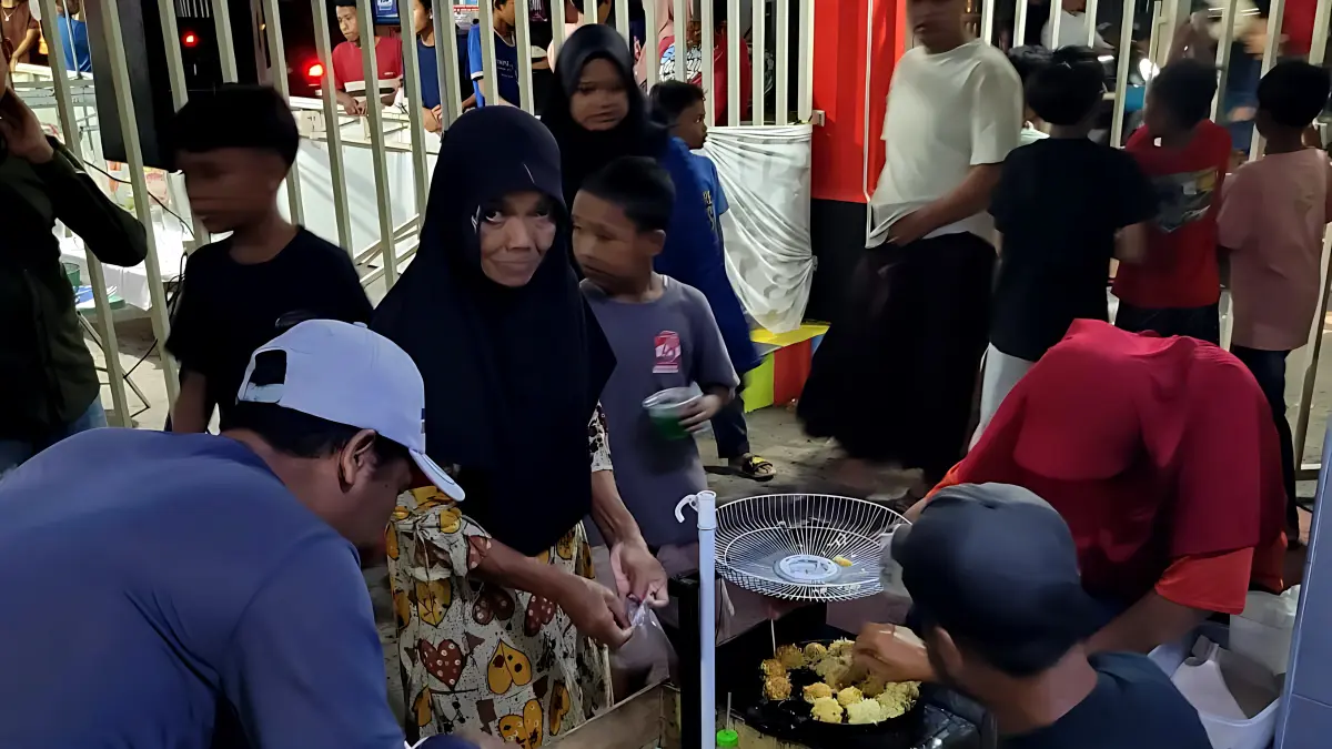 MERIAH : Warga Sapuro Kebulen saat menikmati pasar Jajan Gratis di Kampung nya, dengan mengantri salah satu jajan di depan rumah warga, Jumat malam (21/8/2026).(IST)