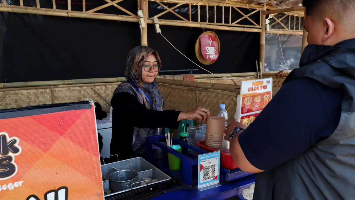 TRANSAKSI : Pembeli saat membayar denganlayana QRIS pada salh satu UMKM usaha ku;iner di Kota Pekalongan. (Lutfi Hanafi/Jawa Pos Metro Pekalongan)