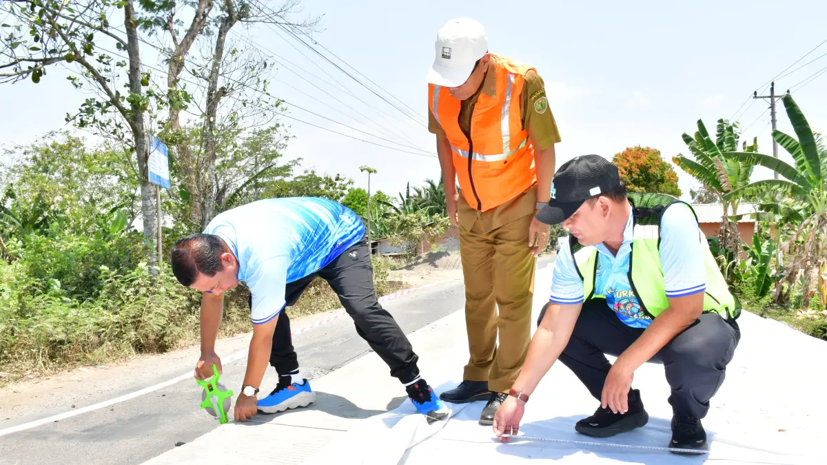CEK PROGRES: Plt Bupati Pekalongan Sukirman saat mengukur lebar dan tebal beton ruas jalan. (Dok. Prokompim)