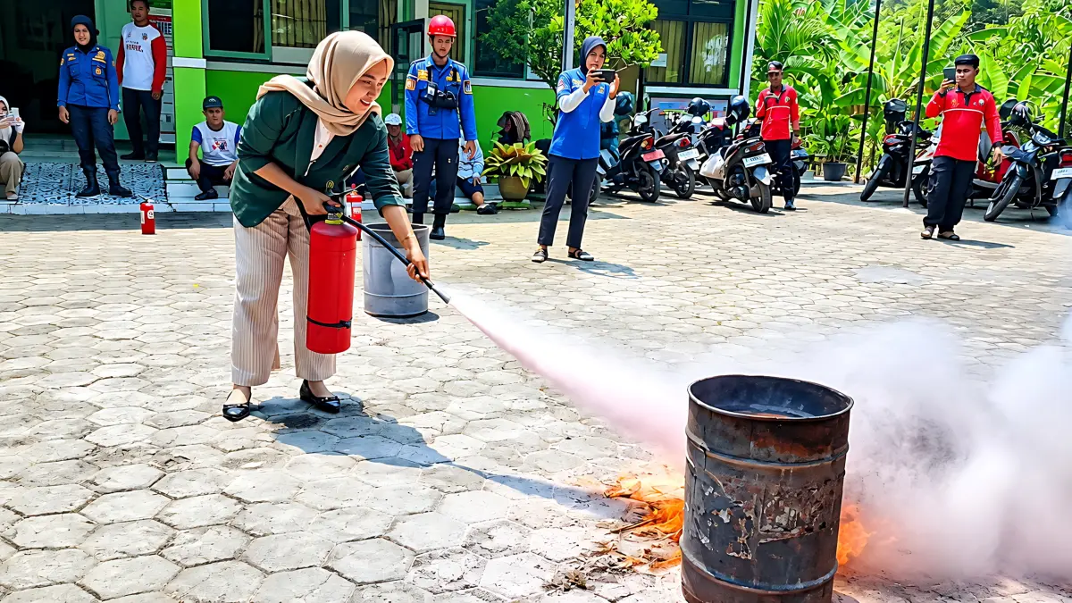 SEMPROT : Salah satu warga Kuryos Pekalongan Selatan saat berlatih memadamkan api dengan APAR di halaman kantor kelurahan setempat, Jumat (18/9/2026).(Lutfi Hanafi/Jawa Pos Metro Pekalongan)