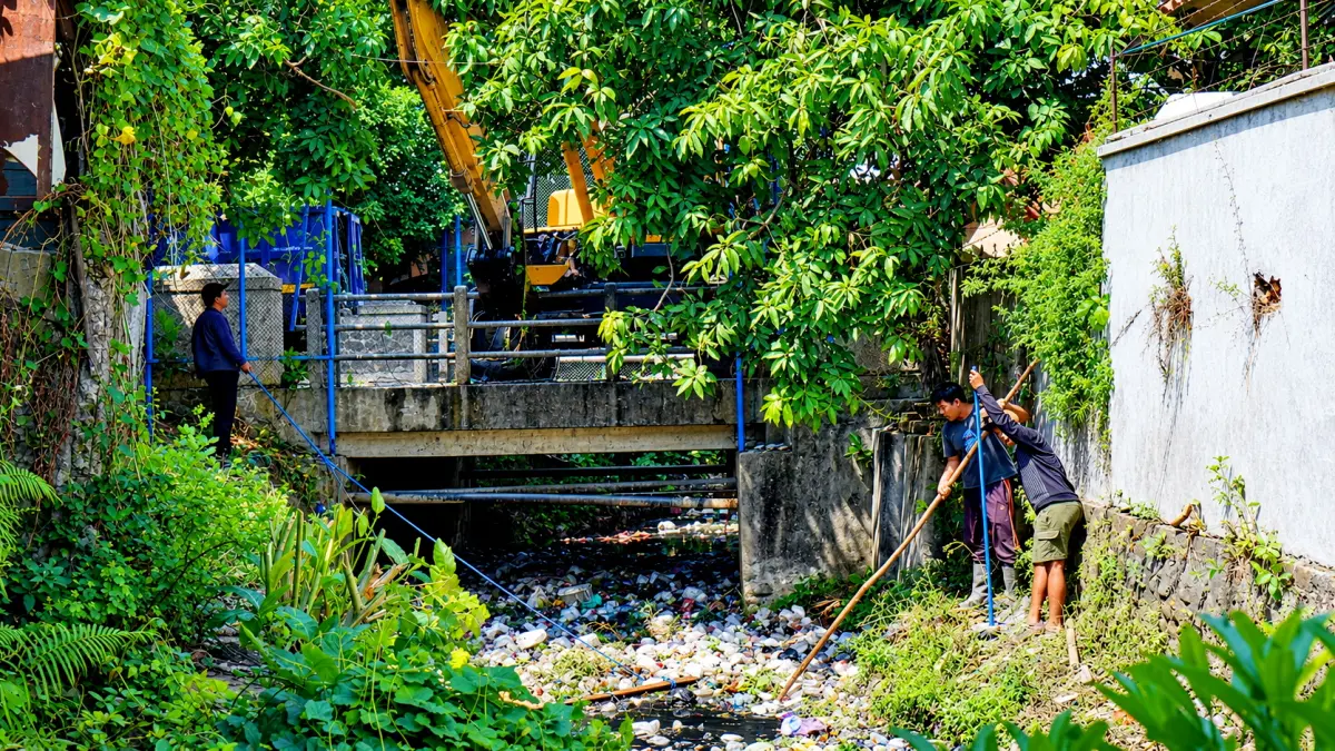 BERSIHKAN : Petugas saat bersihkan tumpukan sampah plastic di sungai Bendan Kergon, dengan manual dan alat berat, pada Kamis (24/9/2026).(IST)