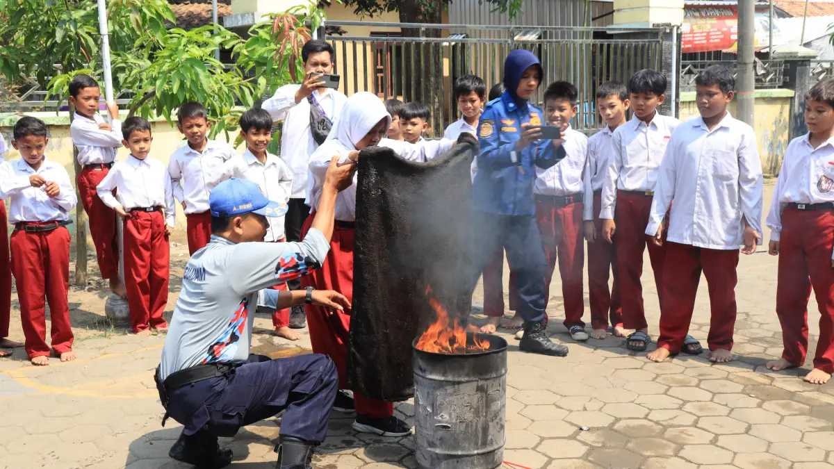 PADAMKAN API : Salah satu siswa SDN Jenggot saat belajar mematikan api dengan karung goni di halam sekolah setempat.(Lutfi Hanafi/Jawa Pos Metro Pekalongan)