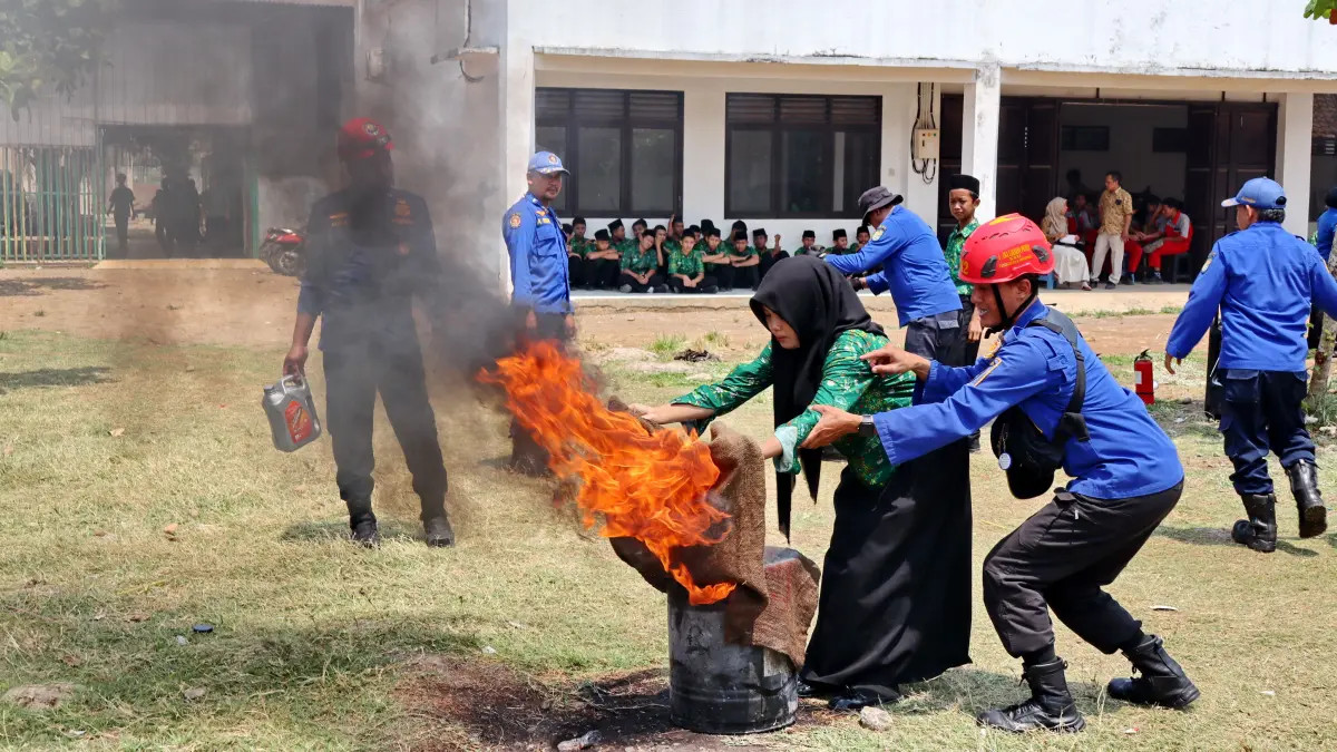 PADAMKAN API : Siswi SMK Syafi’i Akrom saat berlatih memadamkan api di halaman sekolah setempat, Rabu (14/10/2026).(Lutfi Hanafi/jawa Pos Metro Pekalongan)
