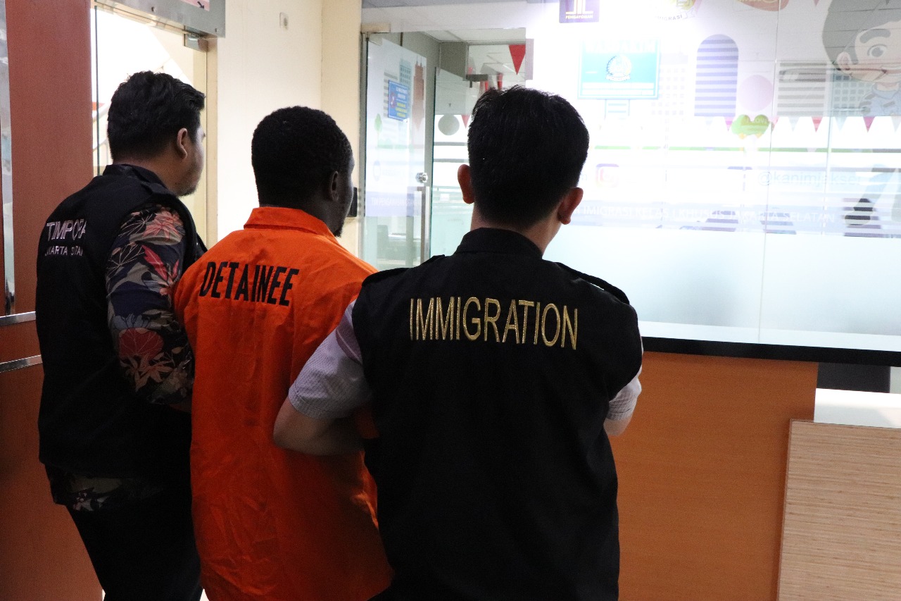 Personel Imigrasi membawa salah satu buron Internasional ke ruang deteni.