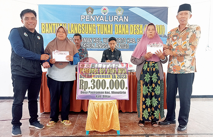 LANCAR: Kepala Desa Pasiraman Sujud Harianto (baju batik) saat penyerahan bantuan langsung tunai, Kamis (30/11).&nbsp;
