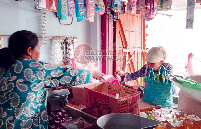 PELAYANAN: Pedagang sembako di Kelurahan Nglegok sedang mengemas tepung yang akan diperjualbelikan.