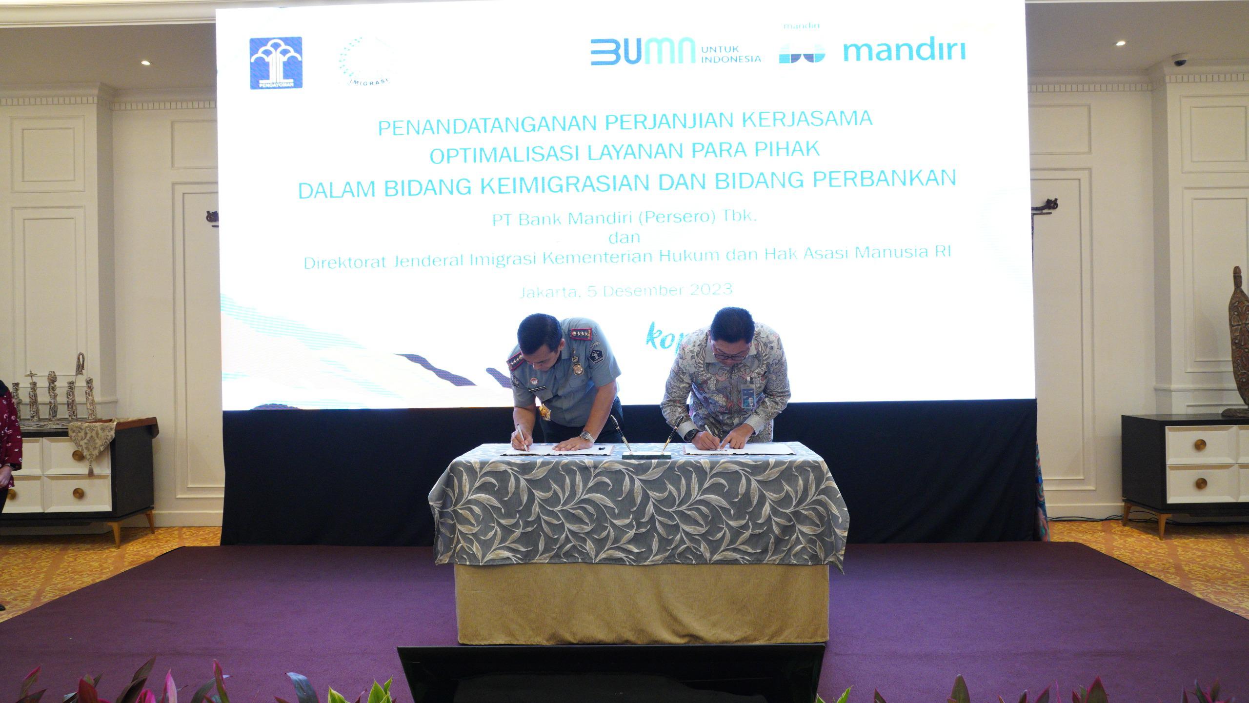 Direktur Jenderal Imigrasi, Silmy Karim dan Direktur Utama Bank Mandiri Darmawan Junaidi  menandatangani kerja sama.