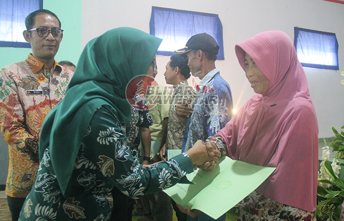 SEMOGA MANFAAT: Bupati Rini Syarifah menyerahkan sertifikat tanah program PTSL kepada warga Desa Wonorejo, Kecamatan Talun, kamis (14/12).