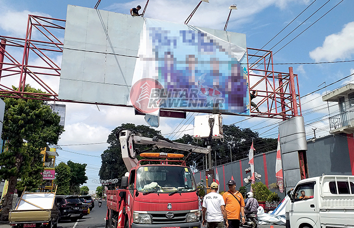 HARUS TERTIB: Petugas menurunkan billboard APK di Jalan Merdeka, Jumat (15/12/2023).