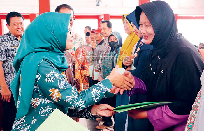 AMANAH: Bupati Rini Syarifah menyerahkan sertifikat kepada warga  Desa Kendalrejo, Kamis (14/12).