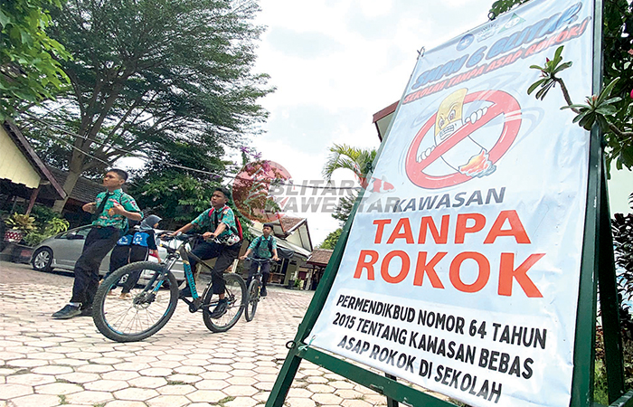 STERIL MEROKOK: Banner kawasan tanpa rokok berdiri di pintu gerbang masuk SMP Negeri 6 Blitar sebagai tindak lanjut penerapan Perda Nomor 1 Tahun 2019 tentang KTR.