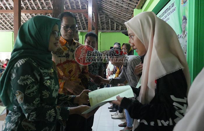 DILINDUNGI HUKUM: Bupati Rini Syarifah didampingi Kepala Kantor  Pertanahan Kabupaten Blitar Budi Hartanto menyerahkan sertifikat  program PTSL kepada warga Desa Selokajang, Kamis (14/12) lalu.