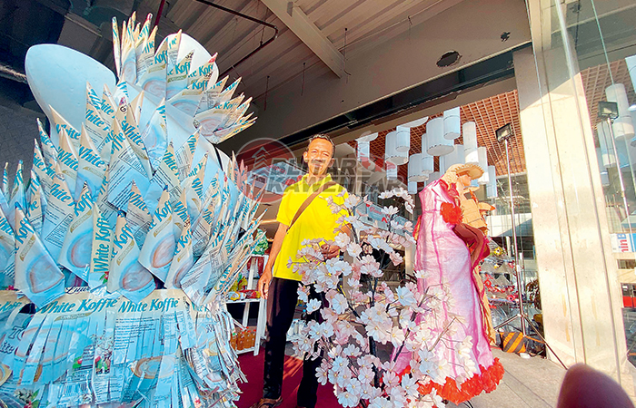 TERAMPIL: Asfarodin Nur Aini (kanan) dan rekannya, Hartono, menunjukkan busana daur ulang limbah plastik produksi pegiat bank sampah Kota Blitar, Kamis (21/12/2023).