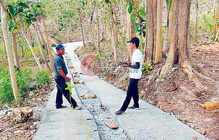 PERMUDAH AKSES: Petugas memeriksa kondisi jalan rabat beton penghubung antardusun di Desa Pasiraman yang selesai dibangun.&nbsp;