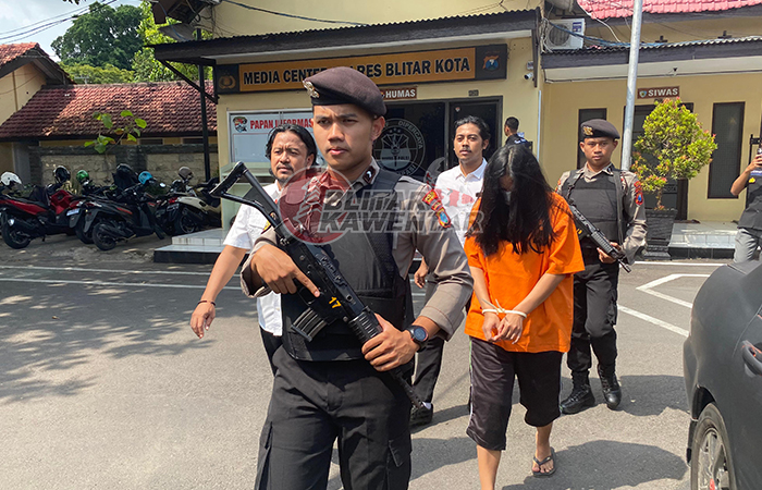 BERAKHIR BUI: Tersangka ESW digelandang polisi usai ditangkap, Rabu (27/12). Sudah sekitar tiga tahun jadi buronan kasus korupsi Bank Kota Blitar.