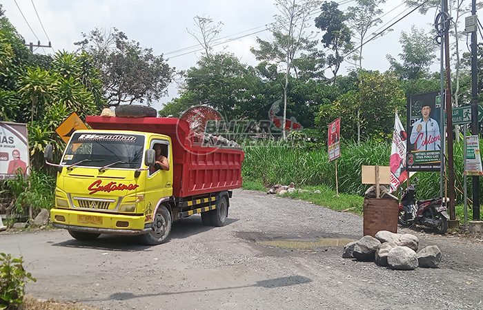 JALAN RUSAK: Truk penambang sedang dialihkan menuju jalan khusus yang sudah ditunjuk desa.