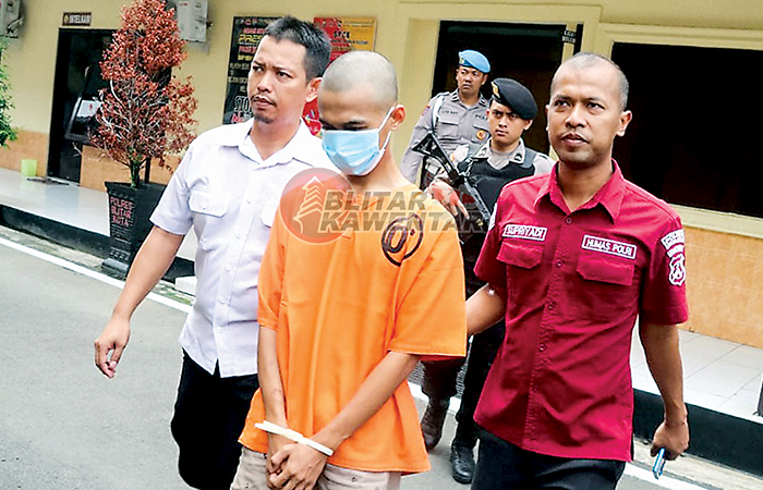 DISULUT EMOSI: Tersangka AF digiring menuju meja rilis usai tertangkap, Rabu (3/1). Dia terancam dihukum penjara seumur hidup.