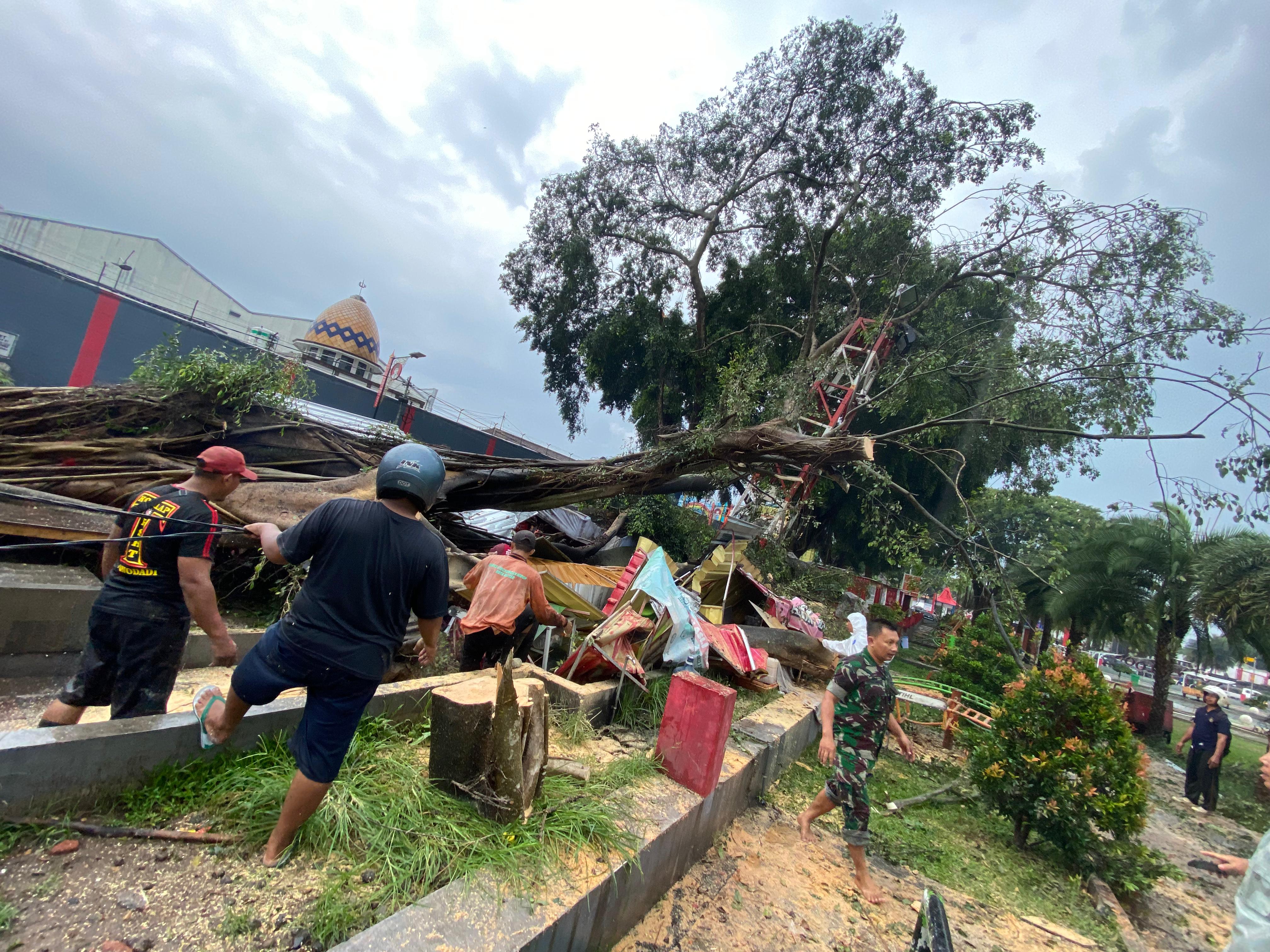 BERBAHAYA: Personel BPBD serta tim gabungan melakukan pembersihan pohon beringin Alun-alun Kota Blitar yang tumbang akibat hujan dan angin kencang, Minggu(7/1/2024).