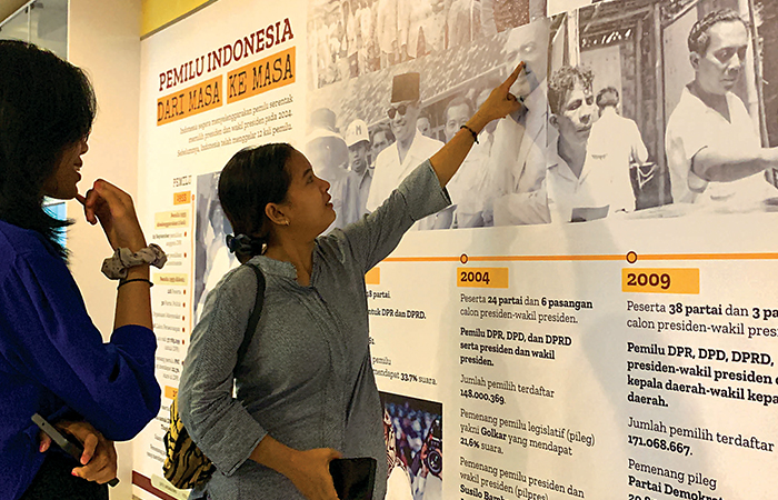 LITERATIF: Pengunjung menikmati sajian infografis tentang sejarah kepemiluan Indonesia dari masa ke masa.