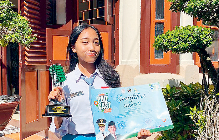 GIAT: Sari Prastiwi menunjukkan trofi dan piagam usai merebut juara 2 lomba Podcast Milenial.