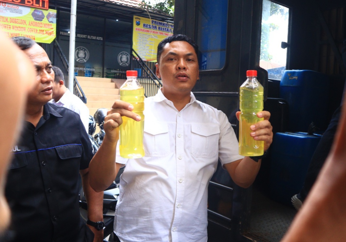 BARANG SITAAN: Kasatreskrim Polres Blitar Kota AKP Hendro Utaryo menunjukkan barang bukti miras yang diamankan dari gudang produksi miras di Kecamatan Kepanjenkidul, Rabu (10/1/2024).