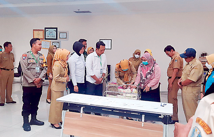 CEK KONDISI: Petugas memeriksa bayi berjenis kelamin perempuan yang diduga dibuang di Kecamatan Ponggok sebelum diserahkan ke Pemprov Jatim.