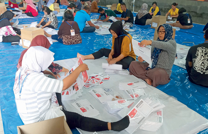 HATI-HATI: Selain melipat, petugas sortir juga mengecek kondisi surat suara memastikan keamanan.