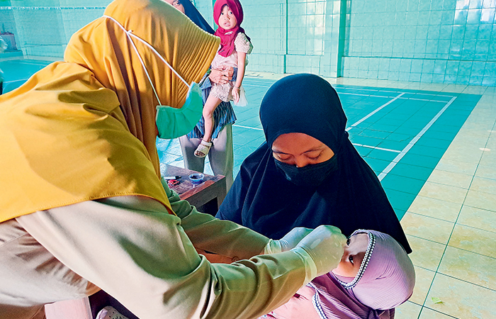 SEREMPAK: Seorang tenaga kesehatan memberikan imunisasi polio pada anak. Di Kabupaten Blitar, capaian imunisasi ini mencapai 95 persen