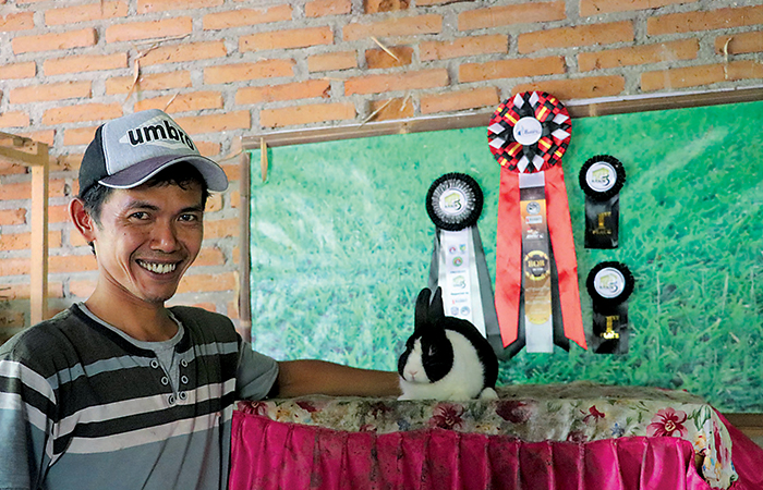 BERBUAH MANIS: Ahmad Nur Wachid dan Seekor kelinci hias jenis anggora miliknya.