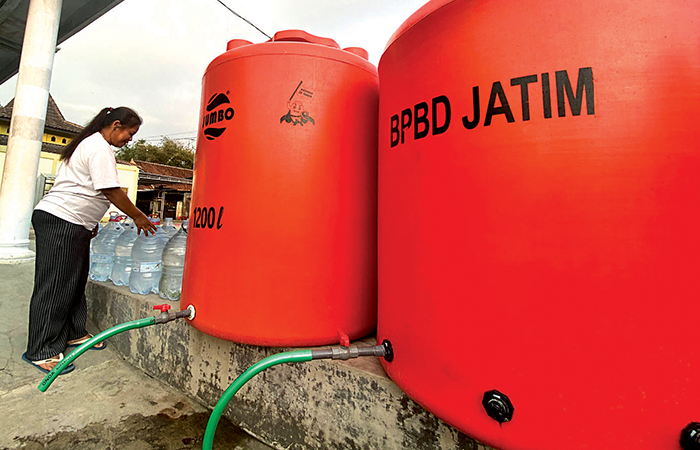 MANFAATKAN BANTUAN: Seorang warga di Lingkungan Jatimalang, Kelurahan Sentul, Kecamatan Kepanjenkidul, mengambil air bersih hasil dropping BPBD selasa (23/1).