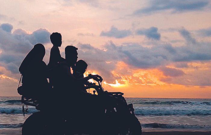 KELUARGA: Satu keluarga sedang mengendarai ATV di Pantai Serang pada sore hari.