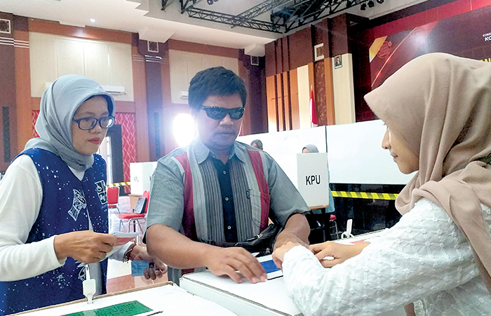 TERTIB: Samsuri didampingi oleh pendamping ketika mengikuti simulasi pemungutan suara di Gedung Kesenian Aryo Kota Blitar, senin (29/1).