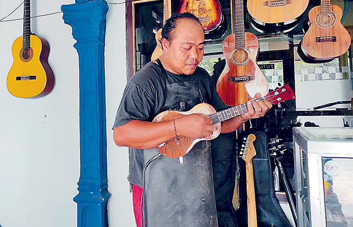 TEKUN: Hariyanto memainkan gitar buatannya di rumahnya Rabu (31/1).