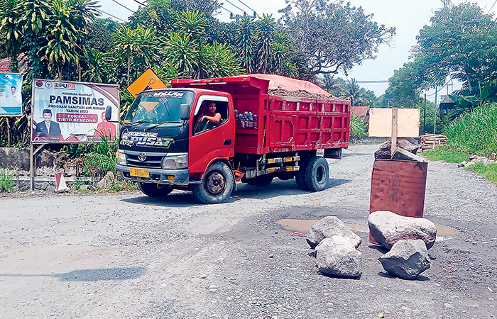 BANDEL: Truk bermuatan pasir melintas di jalan pemukiman di Kecamatan Nglegok yang diduga mengakibatkan infrastruktur rusak.