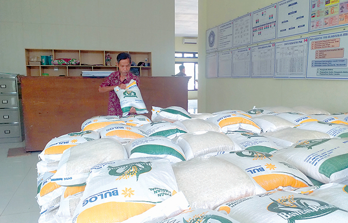 DIBUTUHKAN: Warga mengambil bantuan pangan berupa beras di kantor kelurahan beberapa waktu lalu. Tiap KPM mendapat beras 10 kg.