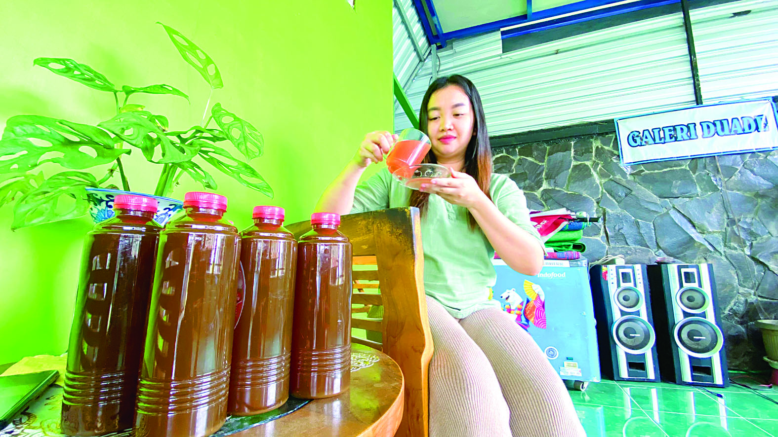 NIKMAT: Debby Fitri Novia Dewi menyeduh sirup jahe merah produksinya, Senin (19/2).
