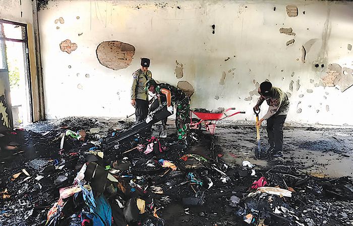 LUDES: Personel polisi dan TNI melakukan pembersihan di ruang laboratorium SDI Kardina Masa usai insiden kebakaran, (21/2).