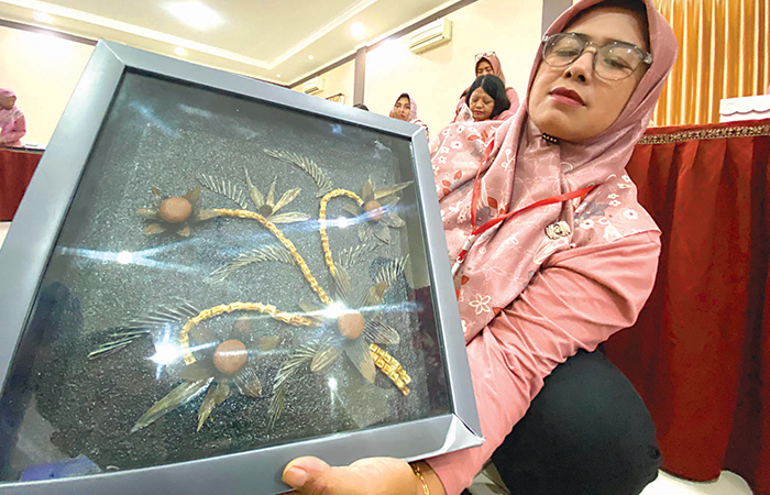 LIMBAH ORGANIK: Widayati, anggota bank sampah di Kecamatan Sananwetan menunjukkan hasil karyanya berbahan dasar tulang ikan.
