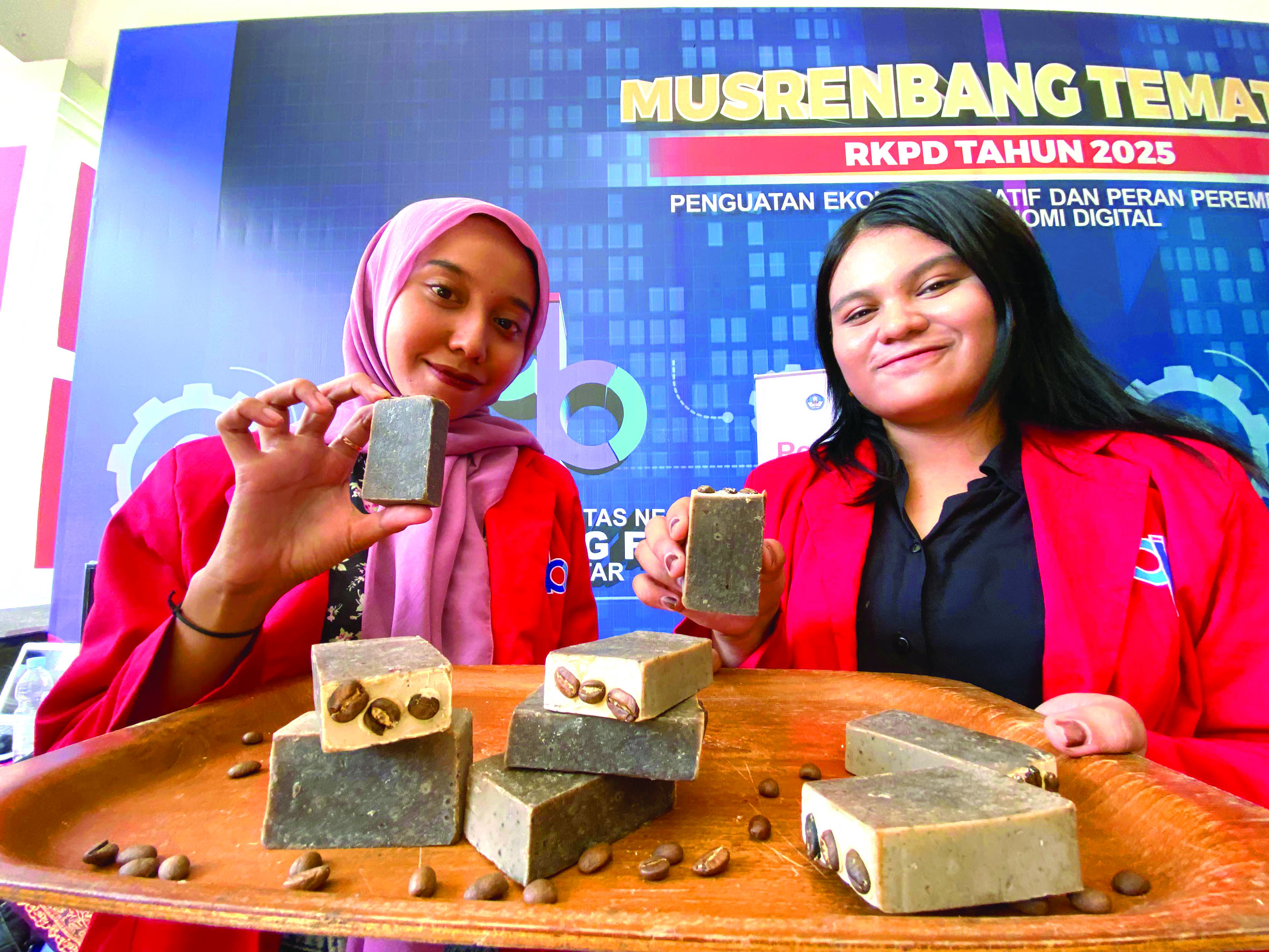 INOVATIF: Yunita Chandra Lestari (kiri) dan Siska Wulan Febriani (kanan) menunjukkan sabun kopi bikinannya, lengkap dengan biji kopi sangrai.