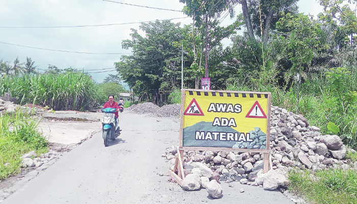 HATI-HATI: Sejumlah pengendara melaju perlahan agar tak tergelincir usai muncul tumpukan material di Desa Penataran, Kecamatan Nglegok.