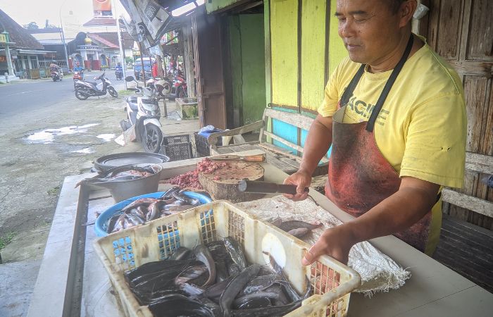 DIMINATI: Pedagang ikan segar di pasar ikan Kanigoro ketika menunggu pembeli.