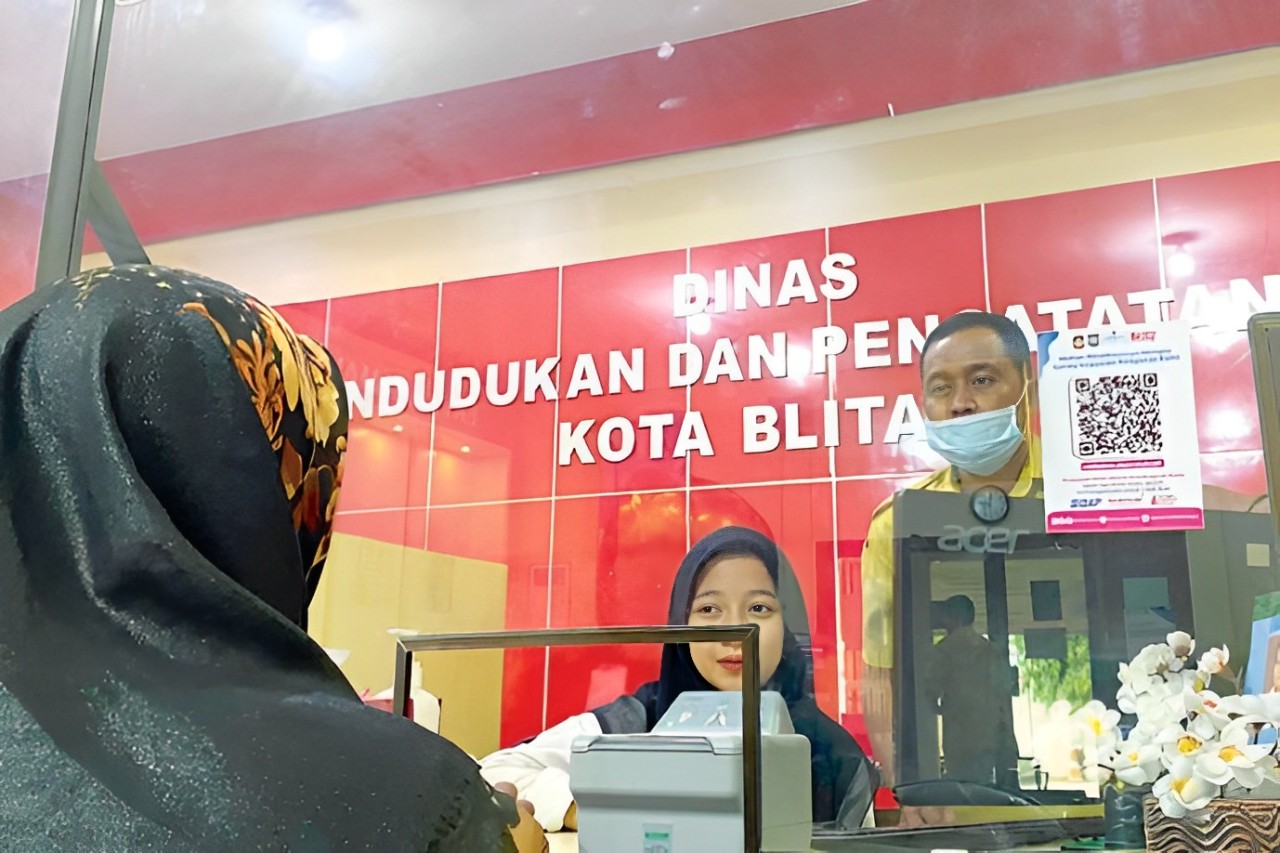 URUS PERPINDAHAN: Pegawai Dispendukcapil Kota Blitar saat memberikan pelayanan kepada seorang warga, Senin (25/3)