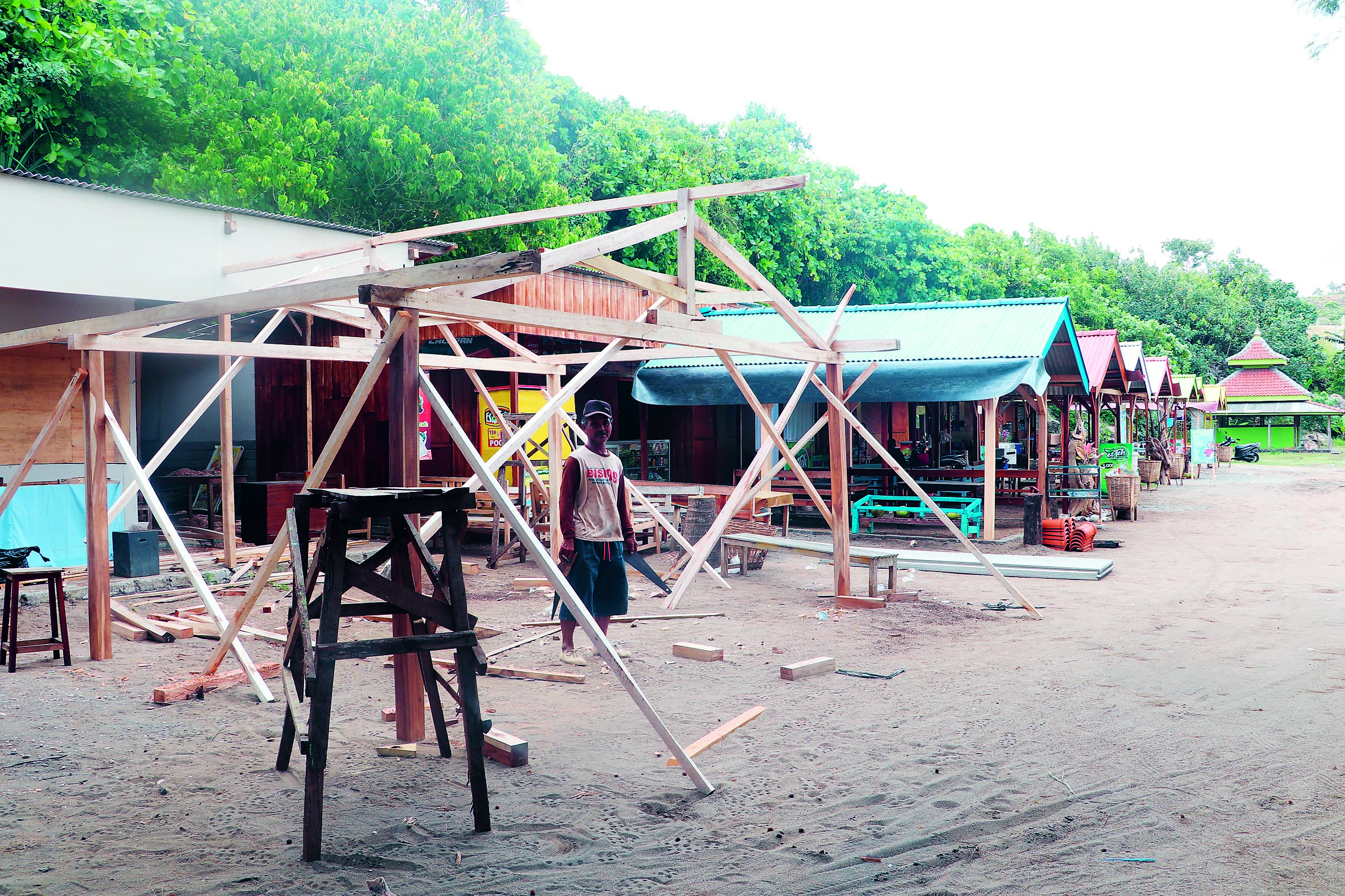 BERBENAH: Pekerja sedang memperbaiki fasilitas di lokasi wisata Pantai Serit, Desa Serang, Kecamatan Panggungrejo.