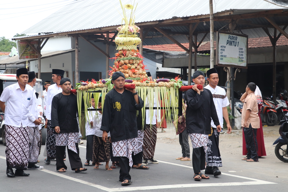 TRADISI: Tumpeng ketupat diarak menuju wisata kampung coklat di Desa Plosorejo Kademangan, sebelum jadi rebutan pengunjung