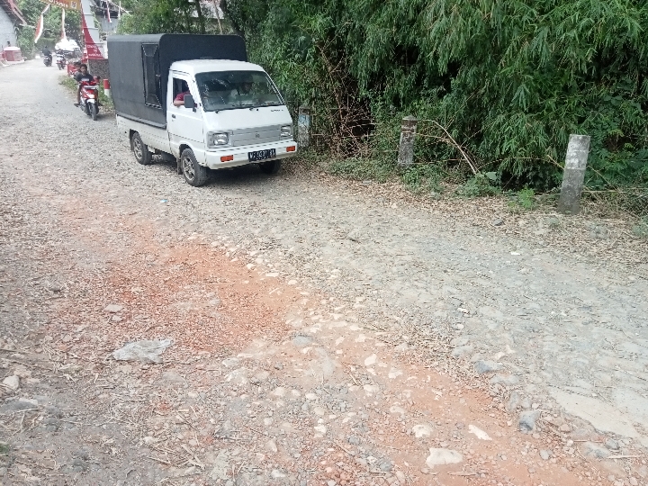 PELAN: Seorang pemotor memacu pelan motornya di atas jalan rusak di wilayah Dusun Widodaren, Desa Suruhwadang, Kecamatan Kademangan.