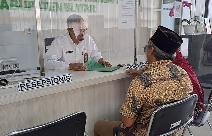 SABAR MENUNGGU: Warga sedang mencari informasi mengenai pendaftaran ibadah haji di Kantor Kemenag Kabupaten Blitar.