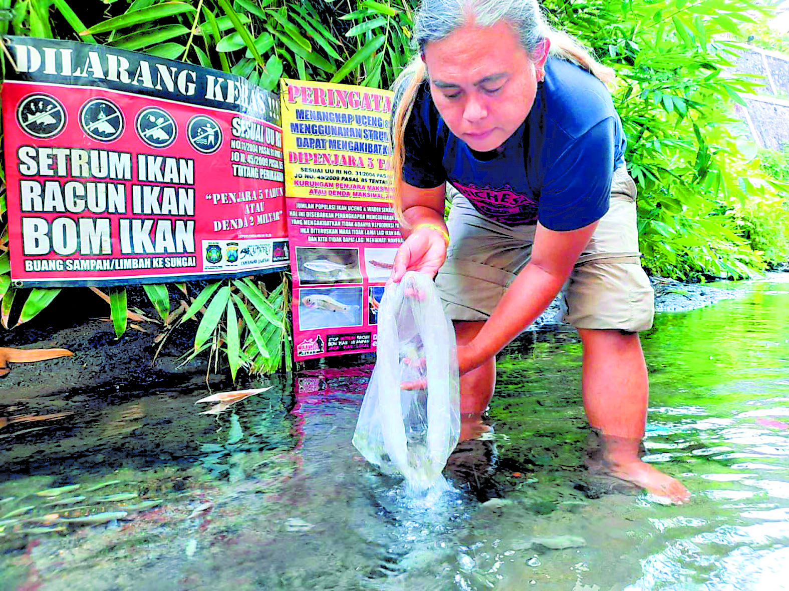 MERAWAT ALAM: Deny Master, 40, merilis ikan-ikan air tawar di sejumlah sungai di Blitar beberapa waktu lalu.