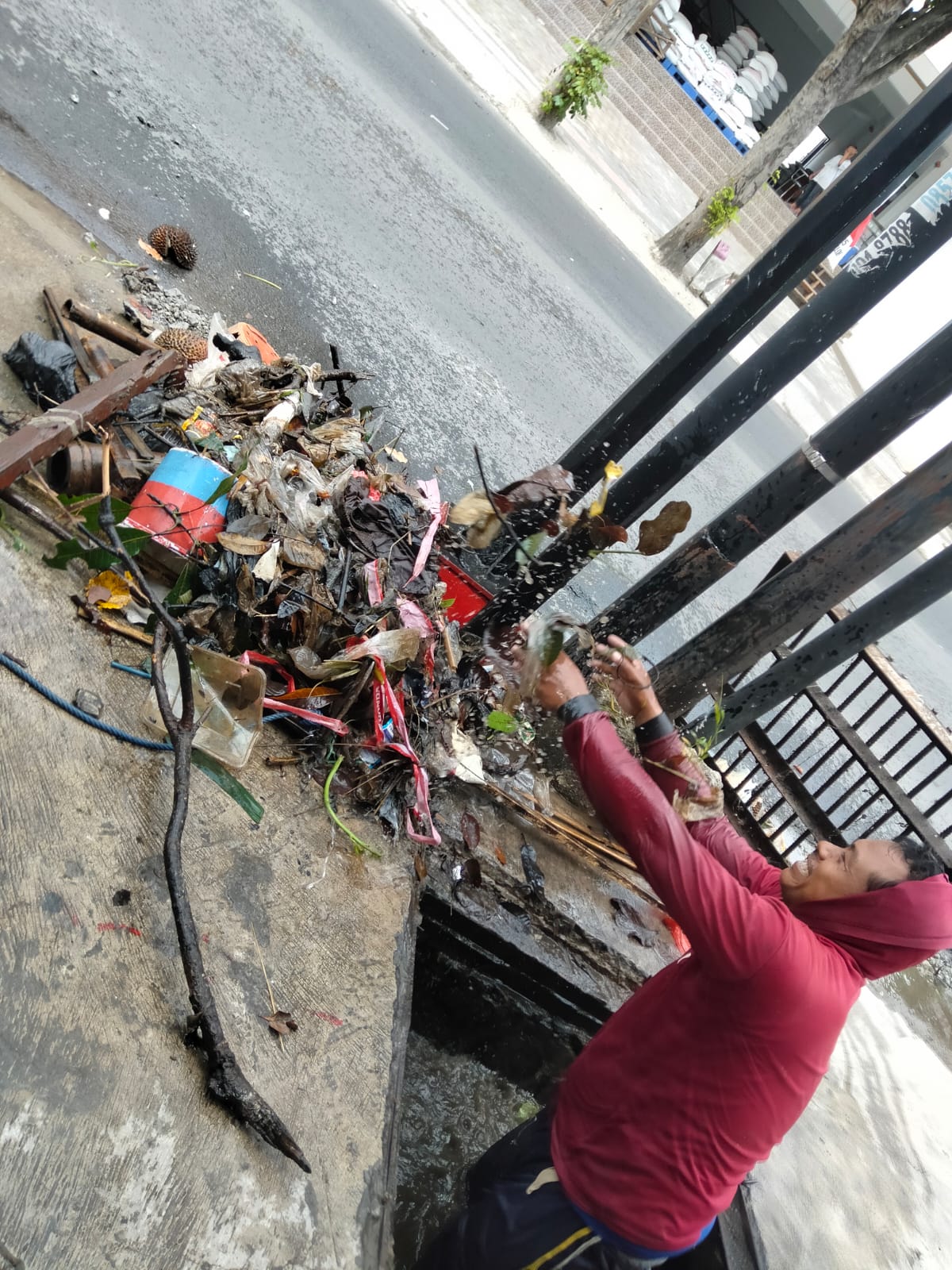 BERSIH-BERSIH: Seorang warga masuk saluran drainase di Jalan Ciliwung saat terjadi luapan air kemarin.